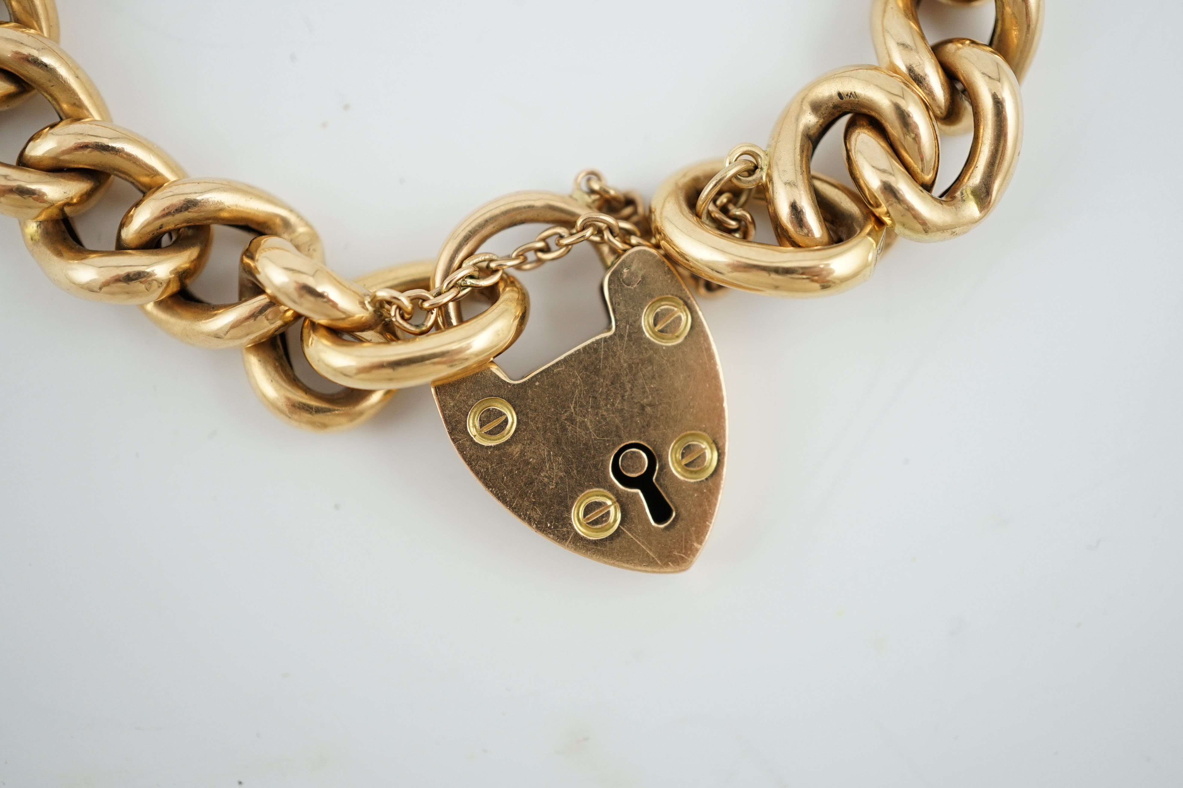 An Edwardian 15ct gold curb link bracelet, with heart shaped padlock clasp